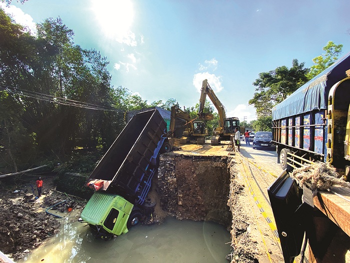 EVAKUASI KENDARAAN: Truk fuso yang terperosok ke sungai yang berada di area proyek Jembatan Pangeleyan, Kecamatan Tanah Merah, Bangkalan, dievakuasi petugas menggunakan ekskavator, Senin (23/6).