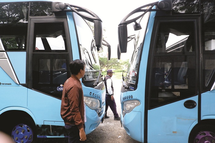 TIDAK BEROPERASI: Pegawai dishub memeriksa kondisi bus Trans Bangkalan di kantornya Selasa (24/6). (VIVIN AGUSTIN HARTONO/JPRM)
