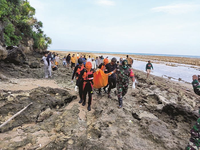 SITA PERHATIAN: Tim gabungan saat mengevakuasi mayat Rahmat yang ditemukan di tepi pantai Dusun Galisek Laok, Desa Kombang, Kecamatan Talango, Sumenep, Minggu (22/6). (IMAM NAHRAWI UNTUK JPRM)