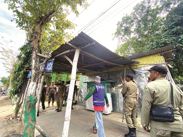 LANGGAR: Petugas Satpol PP dan Damkar Pamekasan membongkar bangunan semipermanen di Jalan Jokotole Rabu (25/6). (AYU LATIFAH/JPRM)