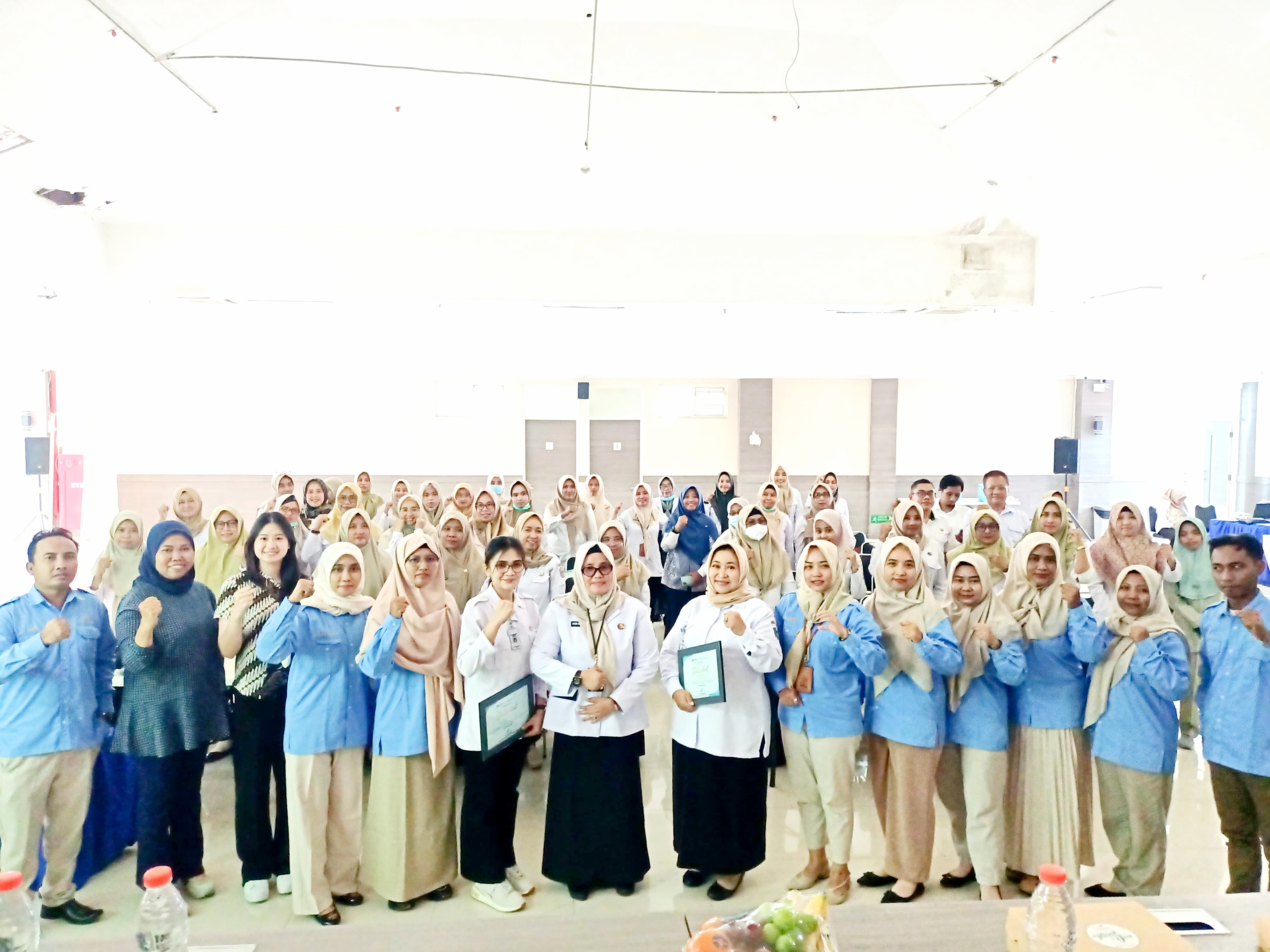 PELAYAN MASYARAKAT: Kadinkes Bangkalan Nur Hotibah (berkerudung dan berkacamata) berfoto bersama peserta seminar dan OJT, Rabu (25/6). (DINKES UNTUK JPRM)