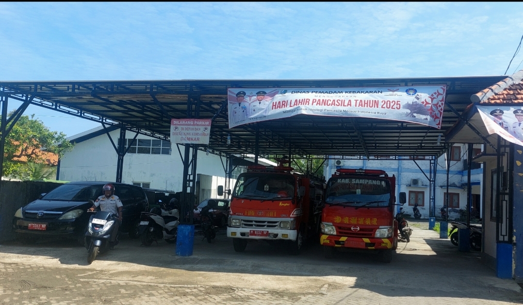 SIAGA: Seorang pegawai berada di sekitar mobil pemadam kebakaran di area parkir kantor Dinas Pemadam Kebakaran dan Penyelamatan Daerah Sampang Selasa (24/6)