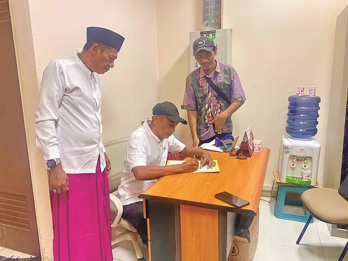 BERDAMAI: Kapas Kolpajung Slamet Efendi menandatangani surat perjanjian damai disaksikan Kaderi dan tokoh Imam Bukhari di Pasar Kolpajung Rabu (25/6). (MOH. IQBAL AFGANI/JPRM)