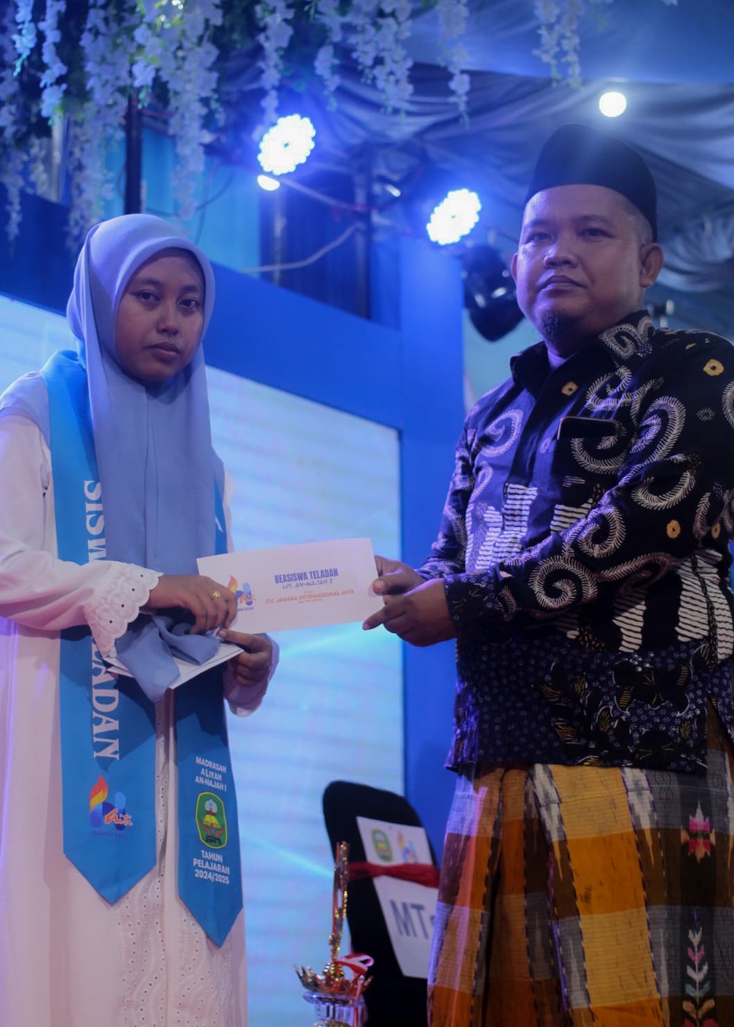 SIMBOLIS: Moh. Subhan menyarahkan beasiswa kepada siswa MTs An-Najah 1 yang dinobatkan sebagai siswa teladan tahun pelajaran 2024-2025 dalam malam puncak Haflatul Imtihan Kamis (26/6).