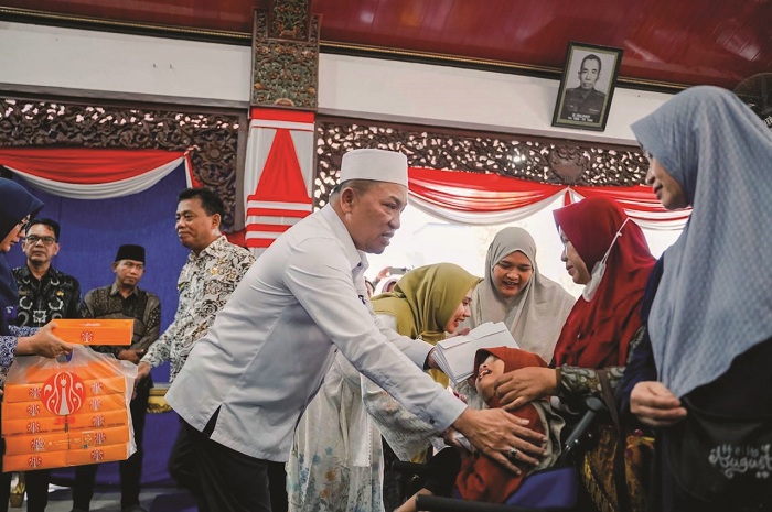 PENUH KASIH: Bupati Sampang Slamet Junaidi (kemeja putih) menyerahkan bantuan secara simbolis kepada penyandang disabilitas di Pendopo Trunojoyo, Kamis (8/5). (PROKOPIM UNTUK JPRM)