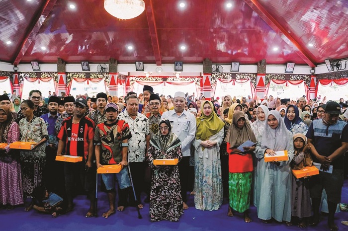 BERSAHAJA: Bupati Slamet Junaidi didampingi Ketua TP PKK Selviana Slamet Junaidi, dan Kadinsos PPPA Edi Subinto berfoto bersama penerima bantuan di Pendopo Trunojoyo, Sampang, Kamis (8/5).