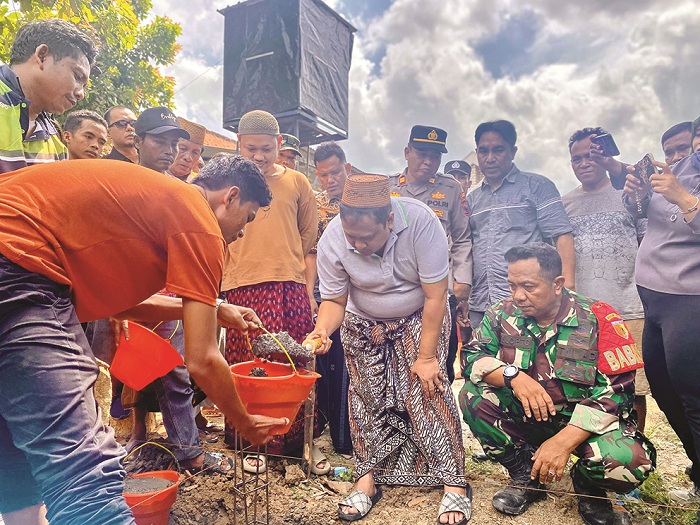 BERSOSIAL: Direktur PT Bawang Mas Group Khairul Umam didampingi Penasihat BMC Lora Abbas Muhammad Rofi&rsquo;i meletakkan batu pertama untuk renovasi rumah di Desa Konang, Galis, Pamekasan, Kamis (3/7).