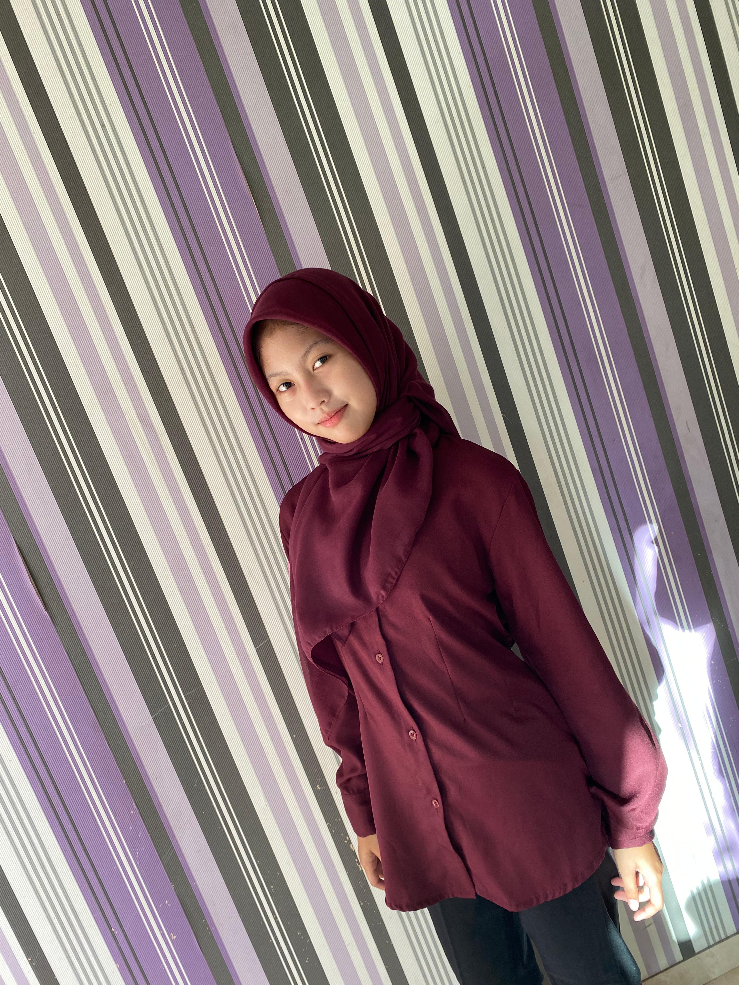 PERCAYA DIRI: Nadia Dwi Octaviana Putri tampil percaya diri dengan pakaian burgundy miliknya di Desa Montok, Kecamatan Larangan, Pamekasan, Sabtu (28/6).
