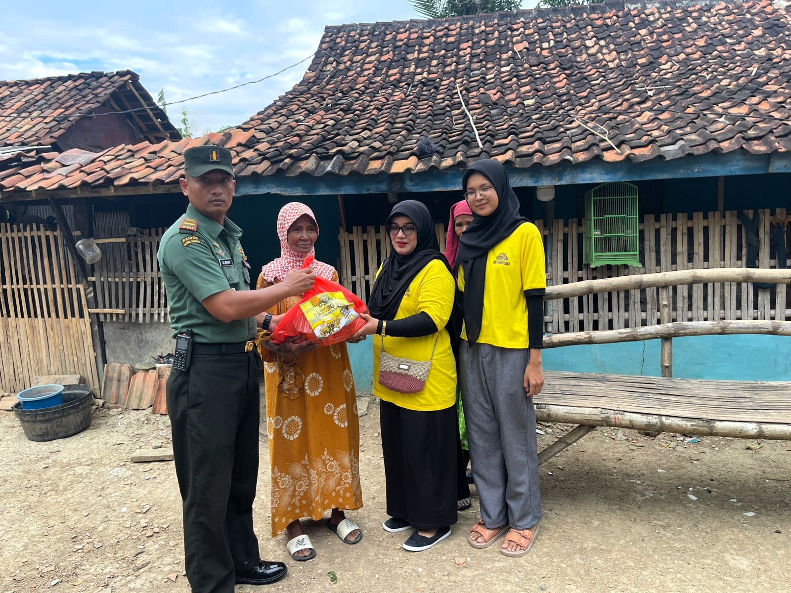 PEDULI: Danramil 0828/11 Tambelangan Kodim 0828/Sampang Letda Inf Ali Murdani didampingi staf PR Payung Mas saat menyalurkan bansos di Desa Samaran, Sampang, Jumat (4/7).
