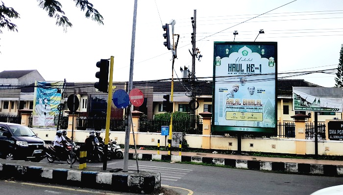 SUMBER PAD: Sejumlah kendaraan bermotor melintas di sekitar reklame di Jalan Soekarno-Hatta, Bangkalan, Senin (7/7). (M. KHOLIL RAMLI/JPRM)