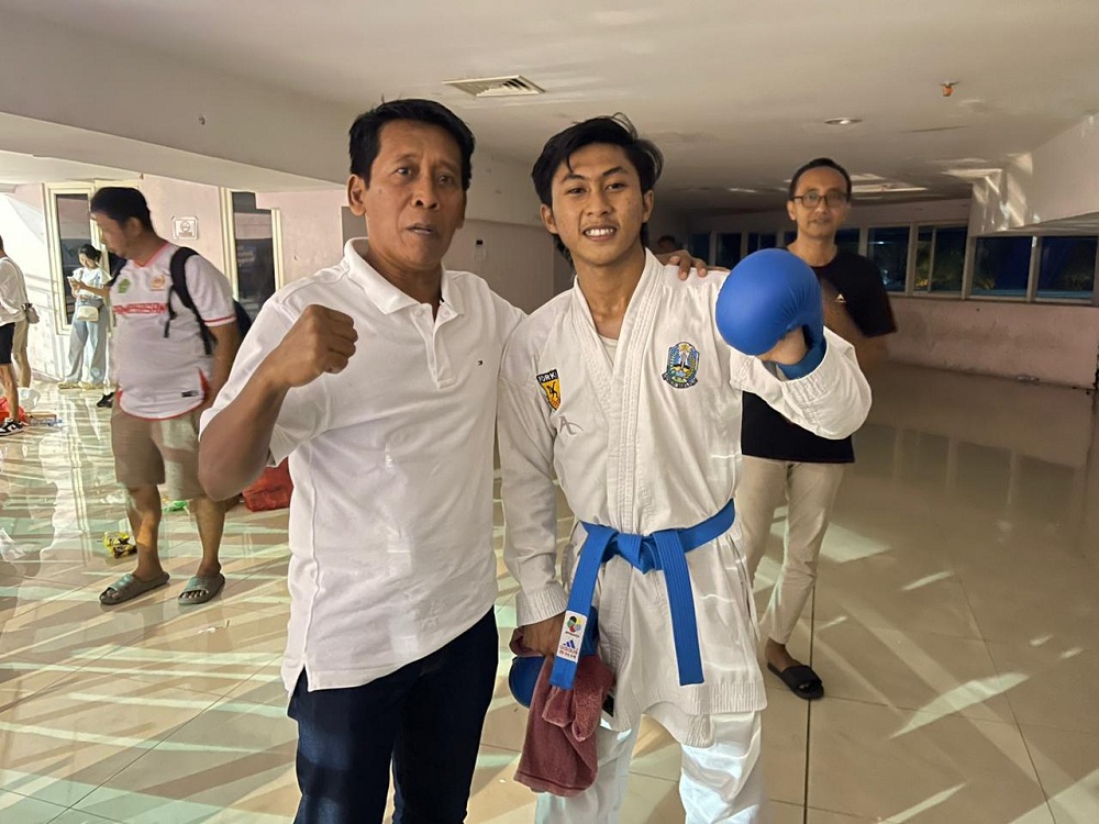 TETAP BERSEMANGAT: Ketua Umum KONI Pamekasan Djohan Susanto berfoto bersama atlet karate Prayoga Dwi Cahyono usai bertanding di Graha Polinema, Jumat (4/7).
