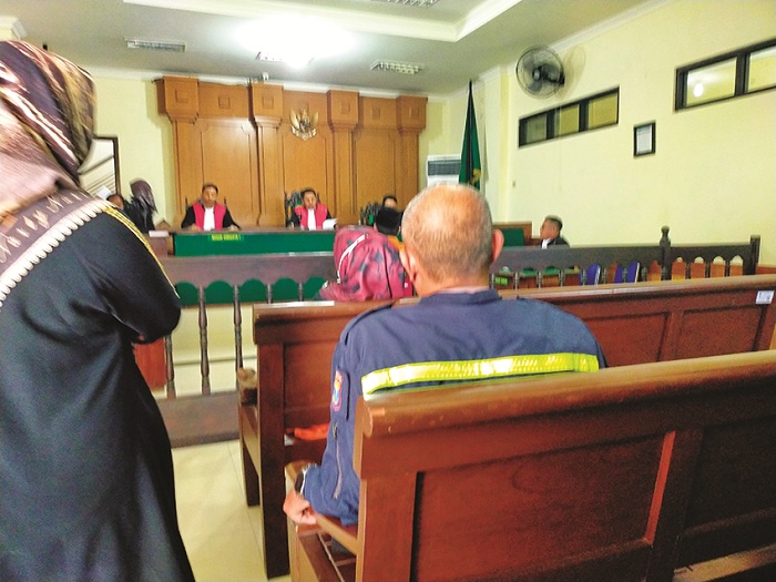 KEMBALI KE SEL: Mufarrohah, oknum Bhayangkari (berkerudung) dikawal petugas usai mengikuti sidang di Pengadilan Negeri Bangkalan Rabu (9/7). (VIVIN AGUSTIN HARTONO/JPRM)