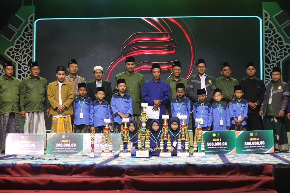 APRESIASI: Ketua PGMNI Jawa Timur Moh. Ali Muhsin (kopiah putih) berfoto bersama dengan pemenang lomba serta panitia event At-Tanzil di IAI Al-Khairat Pamekasan, Senin (7/7) malam.