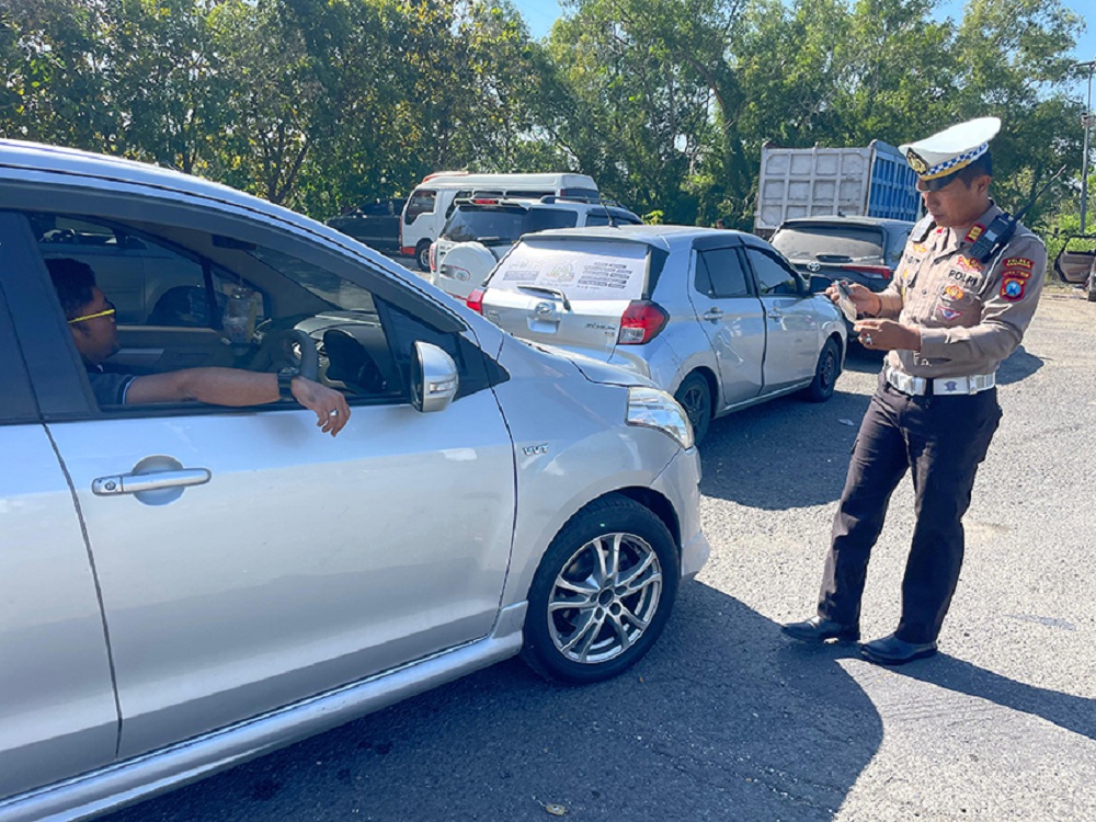 TEGAS: Kasatlantas Polres Sampang AKP Sigit Ekan Sahudi saat mengecek STNK mobil saat memimpin razia di Jalan Raya Jrengik, Sampang, Kamis (10/7).