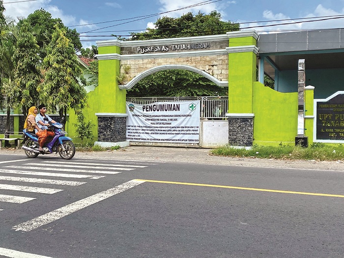 MASUK DI MEJA TENDER: Pengendara sepeda motor melintas di depan Puskesmas Tanah Merah, Bangkalan, yang akan direvitalitasi tahun ini. (JUPRI/JPRM)