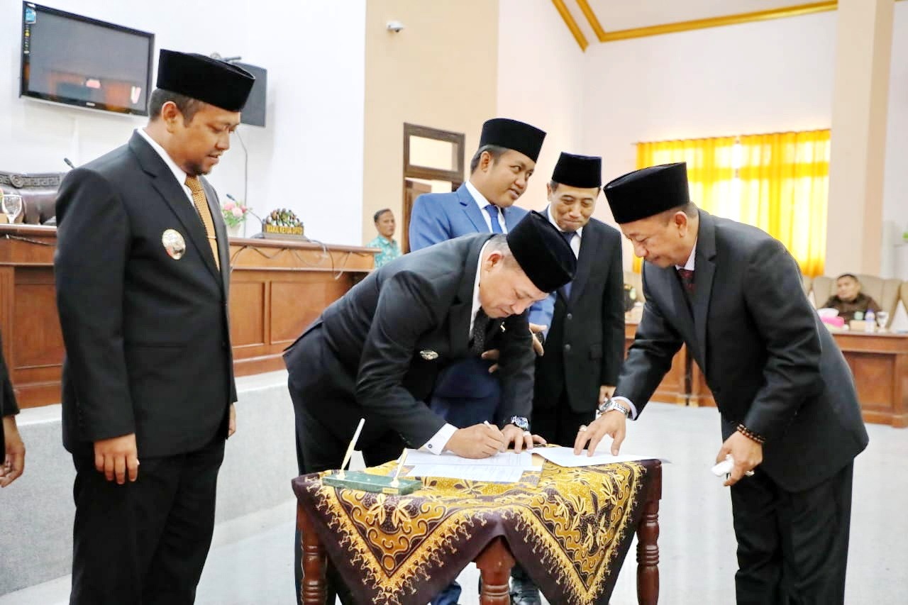 OPTIMISTIS: Bupati Slamet Junaidi didampingi Wabup Ahmad Mahfudz menandatangani berita acara persetujuan Perda RPJMD Sampang 2024&ndash;2029 saat paripurna di kantor dewan, Jumat (11/7).