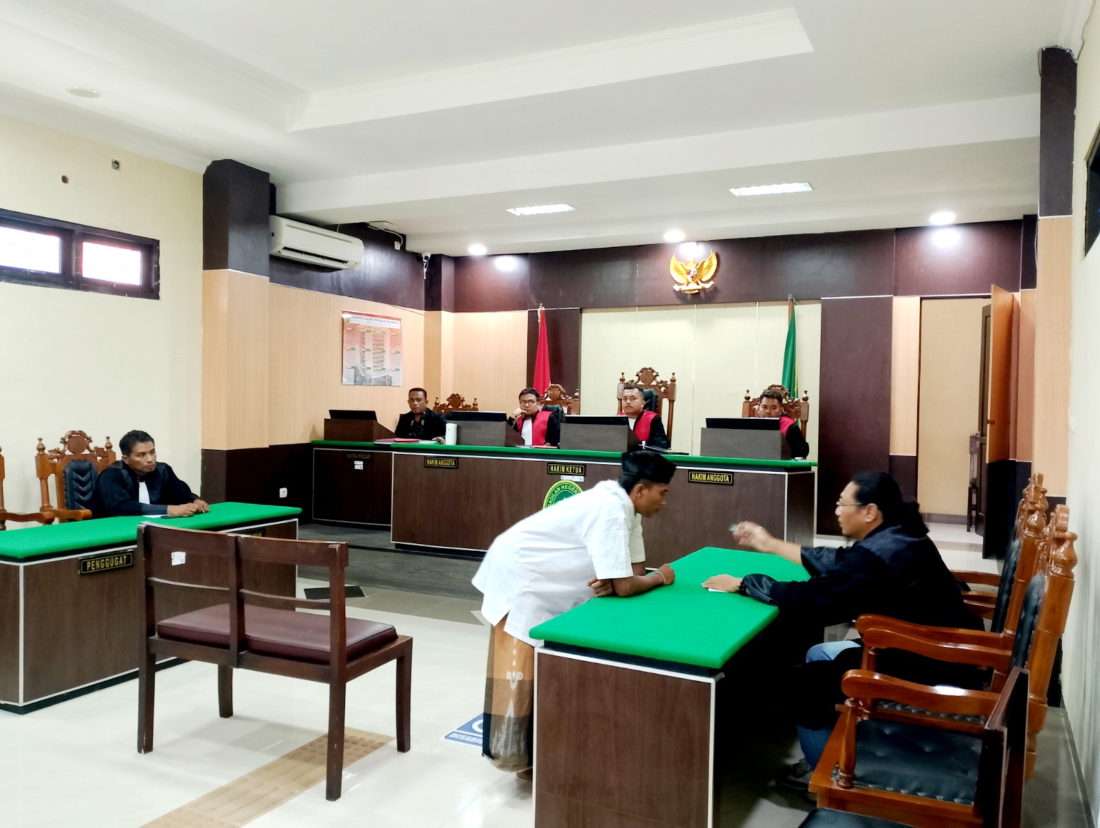 BERSALAH: Rukis berkonsultasi dengan penasihat hukumnya setelah mendengarkan vonis Majelis Hakim PN Sampang, Kamis (9/1). (UBAIDILLAHIR RAIE/JPRM)