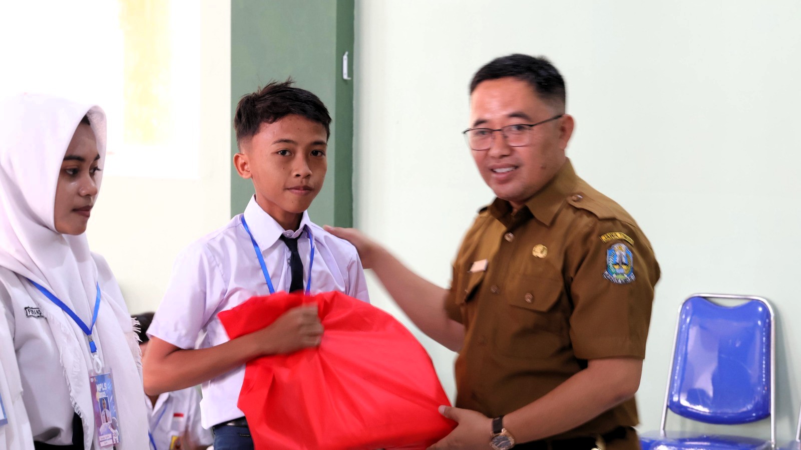 EDUKATIf: Kepala SMAN 1 Ketapang Sulaiman (berseragam dinas) menyerahkan bantuan seragam kepada siswa baru pada acara MPLS, Senin (14/7).
