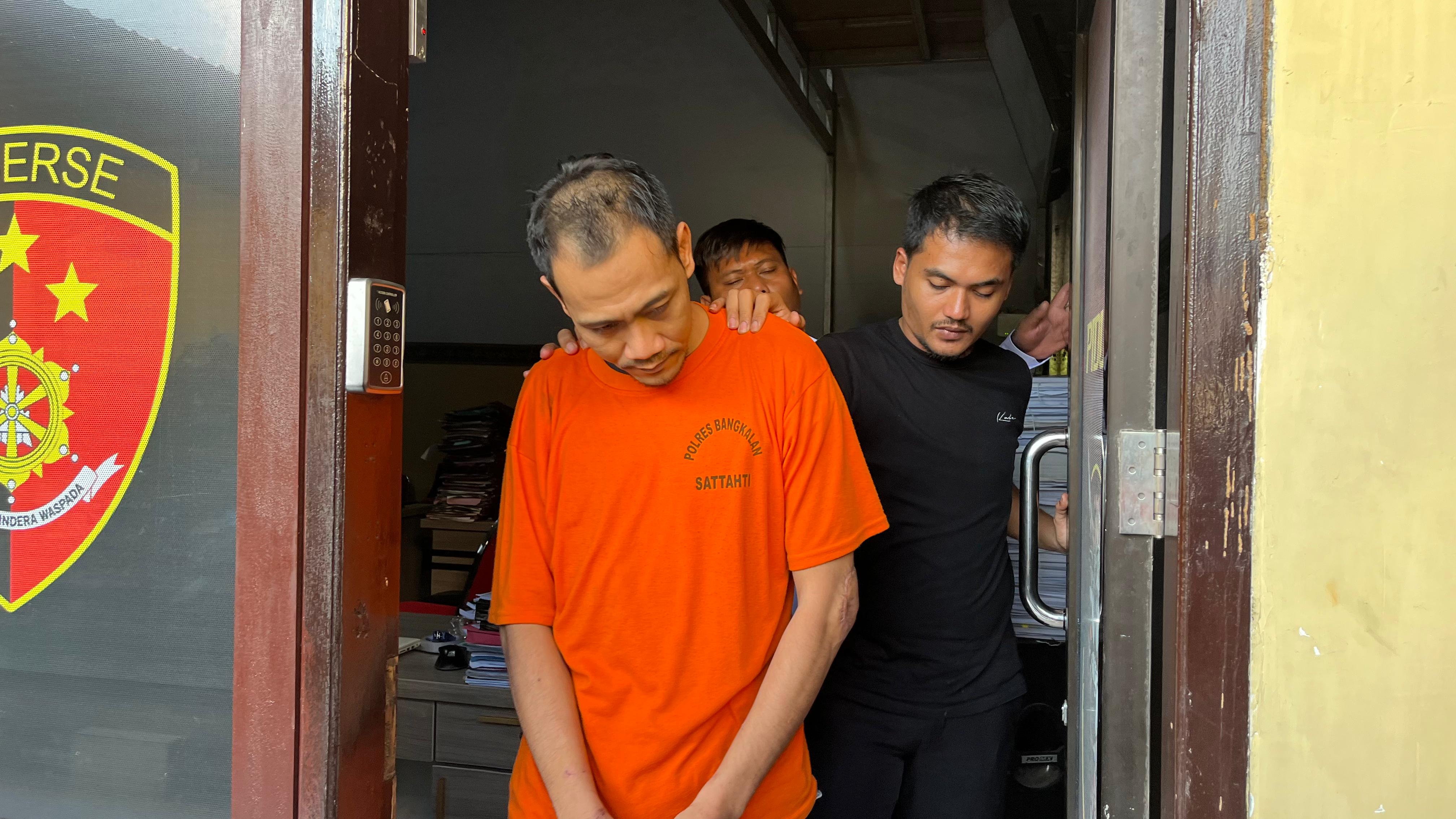 BANDAR NARKOBA: Tersangka Abd. Syukur saat digiring APH dari ruangan penyidik Satreskrim Polres Bangkalan, Selasa (24/6).