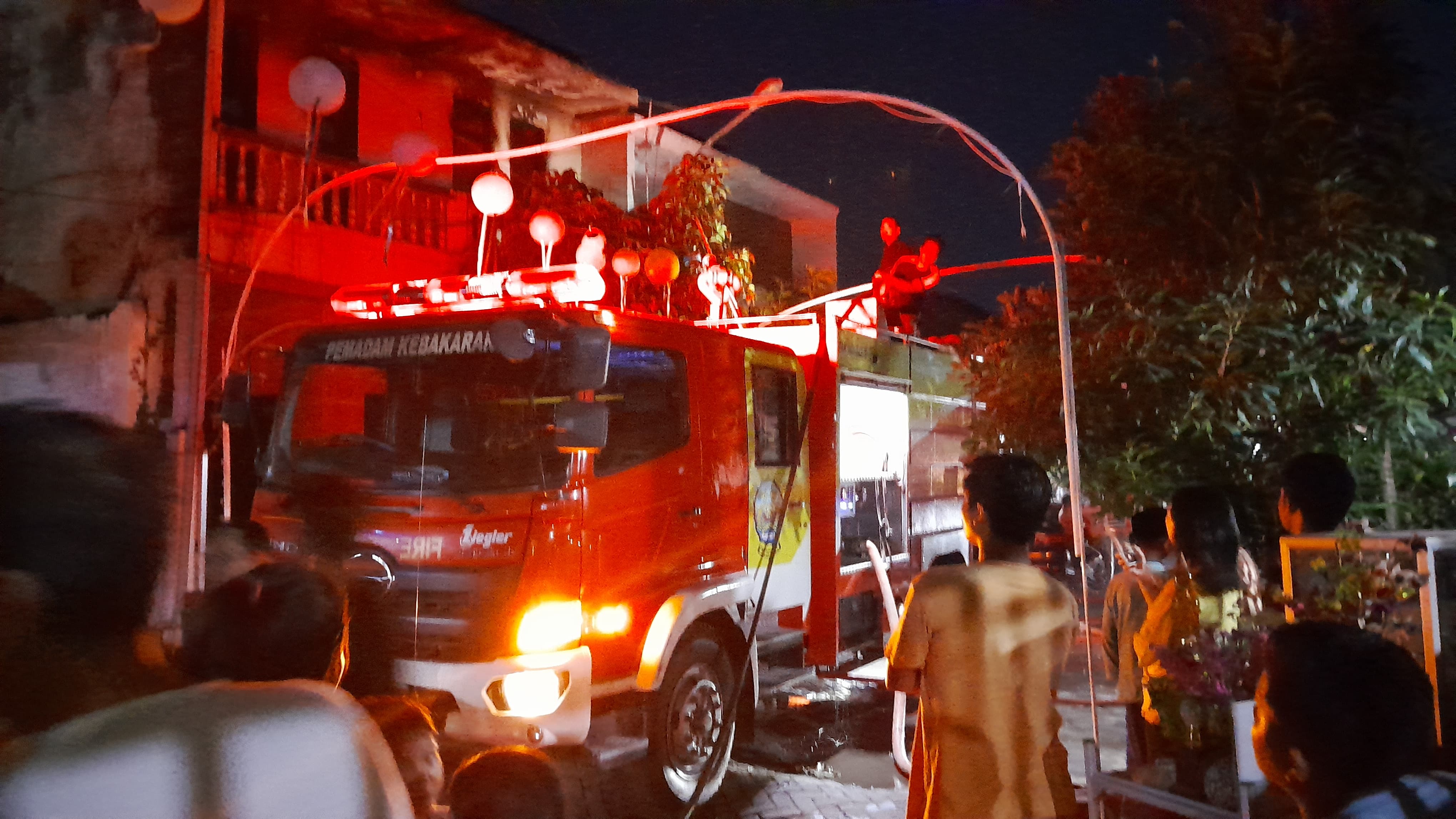 DILALAP SI JAGO MERAH: Tim Damkar Bangkalan sedang melakukan proses pemadaman kebakaran di Perumahan Graha Mentari, Rabu malam (16/7).