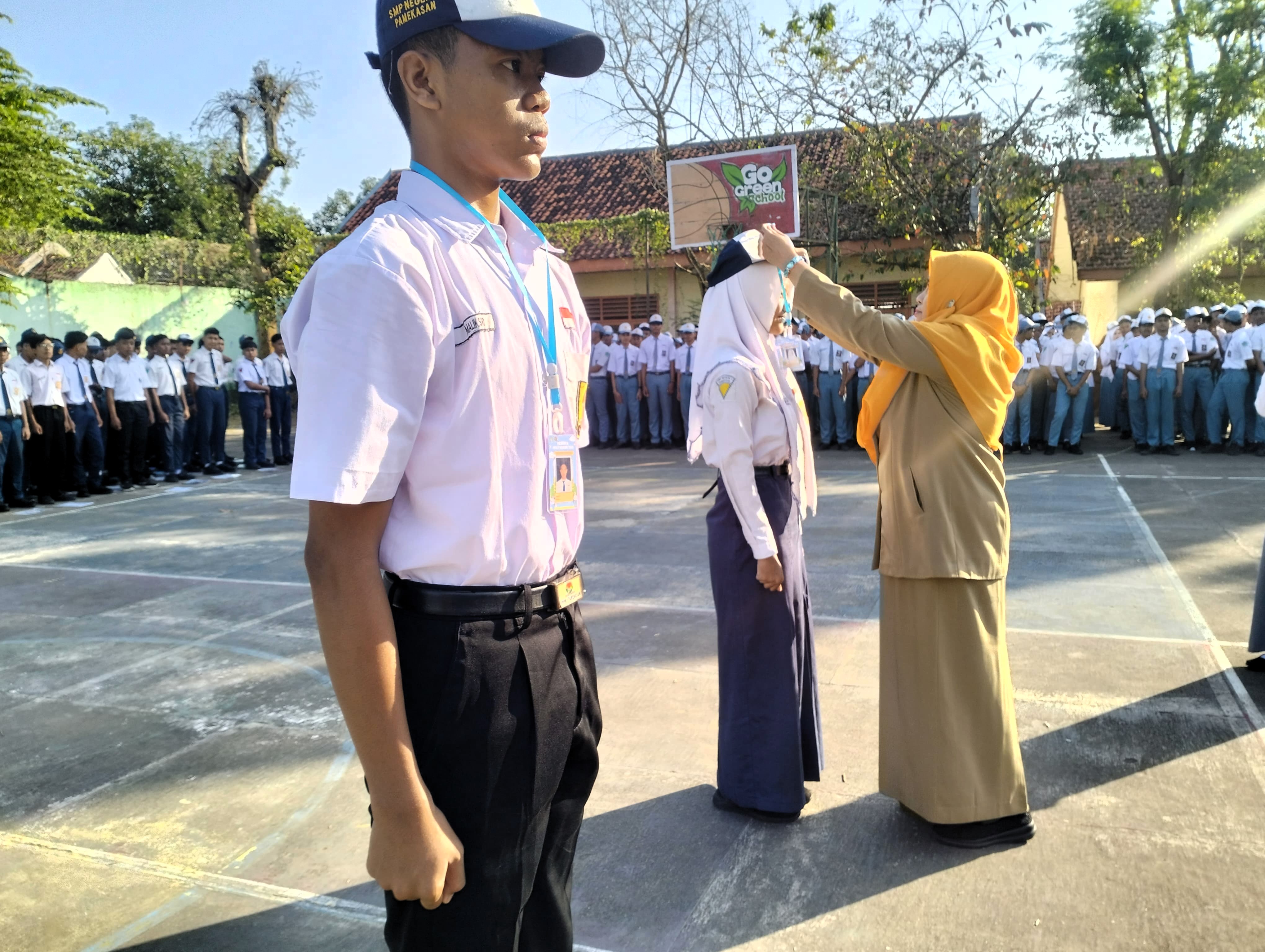 RAMAH: Faridah menyematkan ID card kepada siswa baru saat pembukaan MPLS SMAN 4 Pamekasan Senin (14/7).
