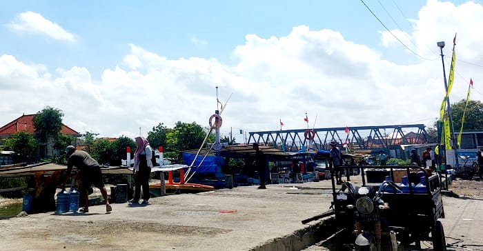 TERIK: Warga menurunkan barang di Pelabuhan Tanglok di Kelurahan Banyuanyar, Kecamatan Sampang, Senin (7/7). (JUNAIDI PONDIYANTO/JPRM)