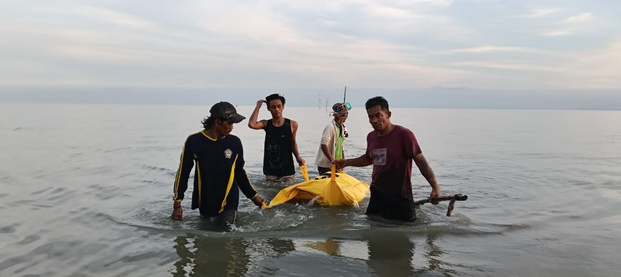 TANPA IDENTITAS: Petugas Polsek Modung, Bangkalan mengevakuasi mayat tanpa identitas bersama warga di pesisir Modung, Kamis (17/7).