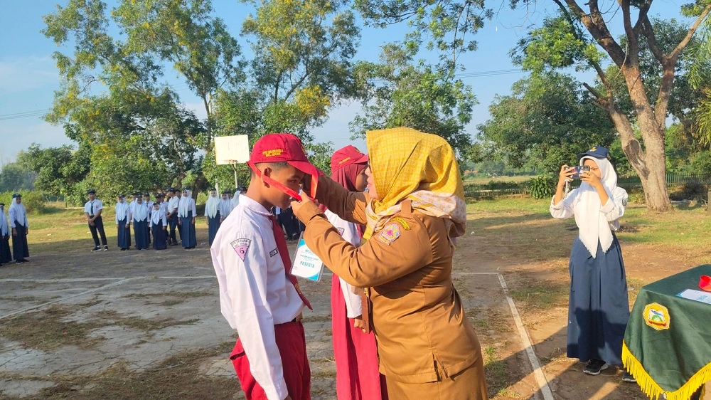 DIMULAI: Kepala UPTD SMPN 1 Socah Tatik Eka Suhartatik menyematkan tanda peserta MPLS.