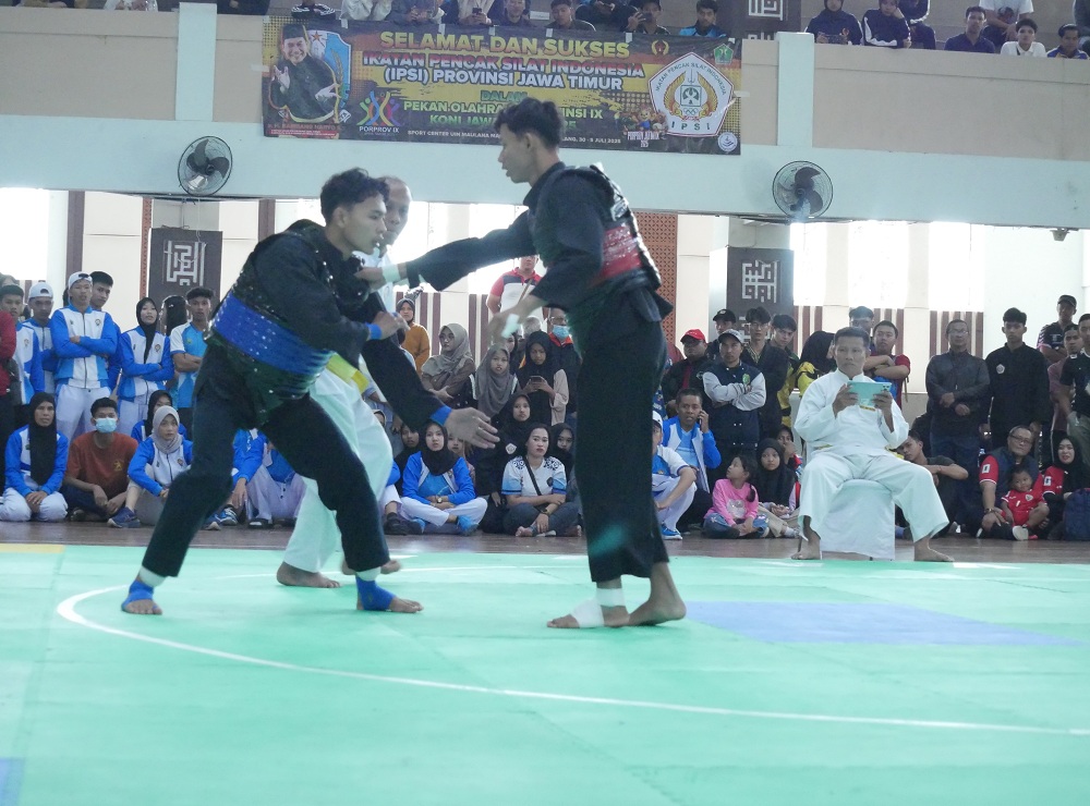 FOKUS: Atlet silat Perisai Putih Sumenep Arya Putra Fernanda (rompi biru) saat berlaga di final pada ajang Porprov IX Jatim di Malang Raya, Sabtu (6/7)