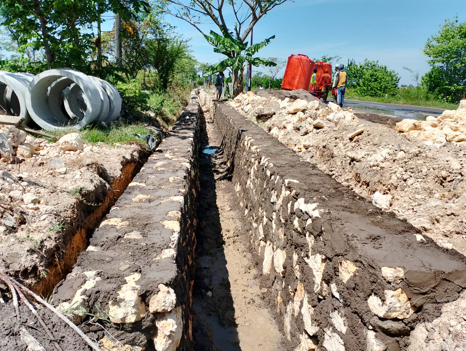 BELUM SELESAI: Pekerja sedang mengerjakan proyek drainase yang bersumber dari dana BK Provinsi Jatim di Desa Apaan, Sampang, Kamis (17/7).