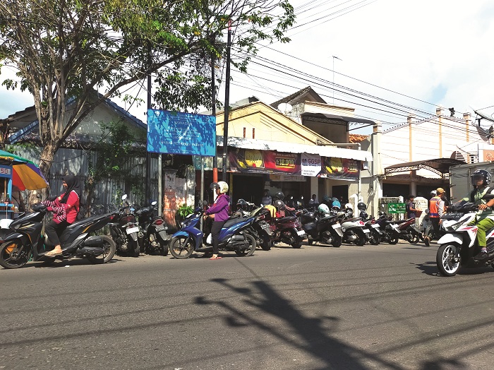 KONVENSIONAL: Juru parkir di Jalan KH Moh. Kholil Bangkalan tengah menjaga kendaraan, Jumat (4/7). (VIVIN AGUSTIN HARTONO/JPRM)