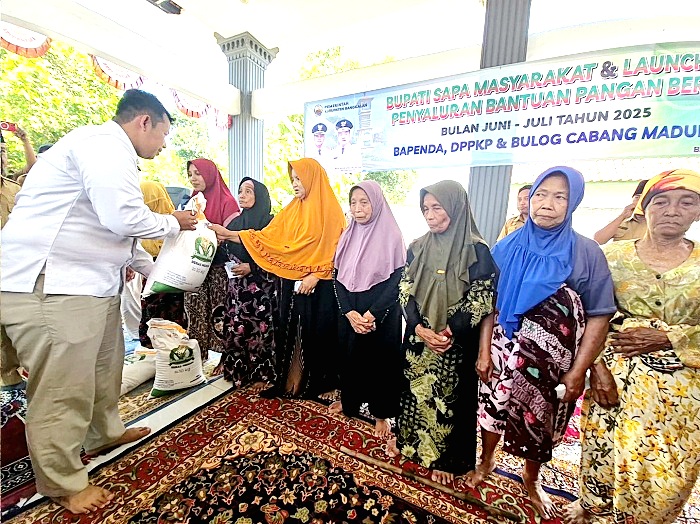 BANTUAN: Direktur Perum Bulog Cabang Madura Ahmad Rofi&rsquo;i menyalurkan banpang beras kepada warga Desa Sobih, Kecamatan Burneh, Senin (21/7). (PERUM BULOG CABANG MADURA UNTUK JPRM)