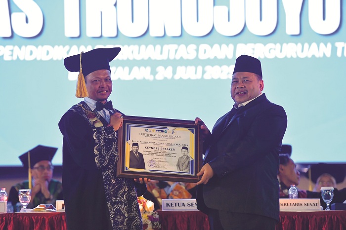 KENANG-KENANGAN: Rektor UTM Prof Dr Safi&rsquo; menyerahkan cenderamata kepada anggota BPK RI Fathan Subchi usai mengisi orasi ilmiah Kamis (24/7). (UTM UNTUK JPRM)