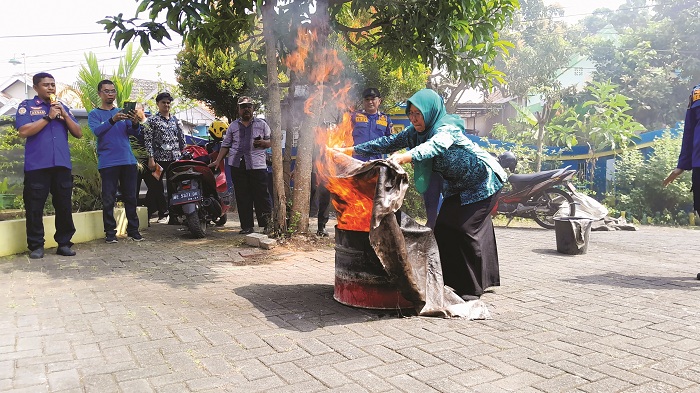 ANTUSIAS: Warga Desa/Kelurahan Kraton, Bangkalan, mengikuti simulasi memadamkan api di kantor kelurahan setempat Kamis (24/7). (M. KHOLIL RAMLI/JPRM)