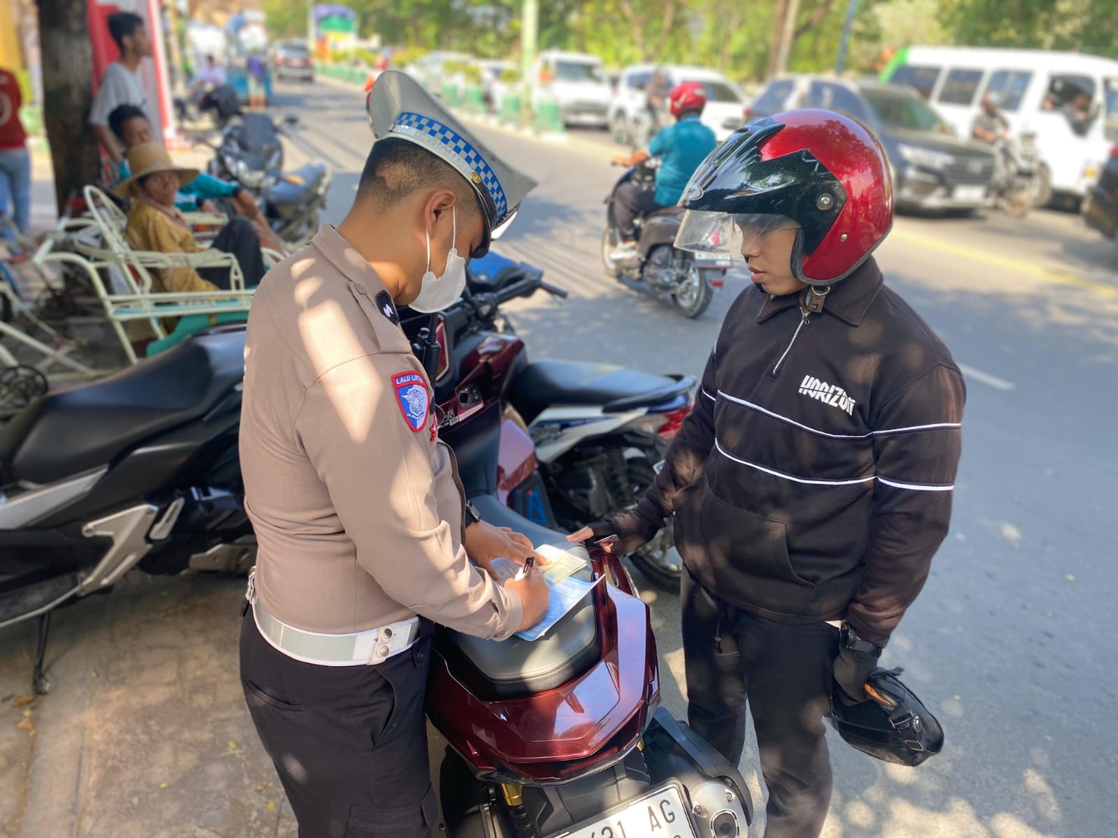 TAK JERA: Polisi menilang pelanggar lalu lintas di Jalan Trunojoyo Pamekasan, Jumat (18/7).