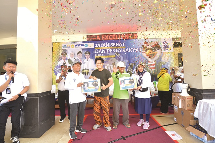 BERUNTUNG: Rektor UTM Prof Dr Safi&rsquo; menyerahkan hadiah utama umrah kepada dua pemenang undian Minggu (27/7). (UTM UNTUK JPRM)