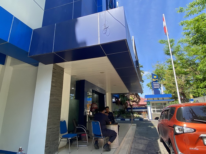 SANTAI: Satpam sedang berjaga di depan Kantor Pengawasan dan Pelayanan Bea dan Cukai Tipe Madya Pabean C Madura, Selasa (22/7). (AYU LATIFAH/JPRM)