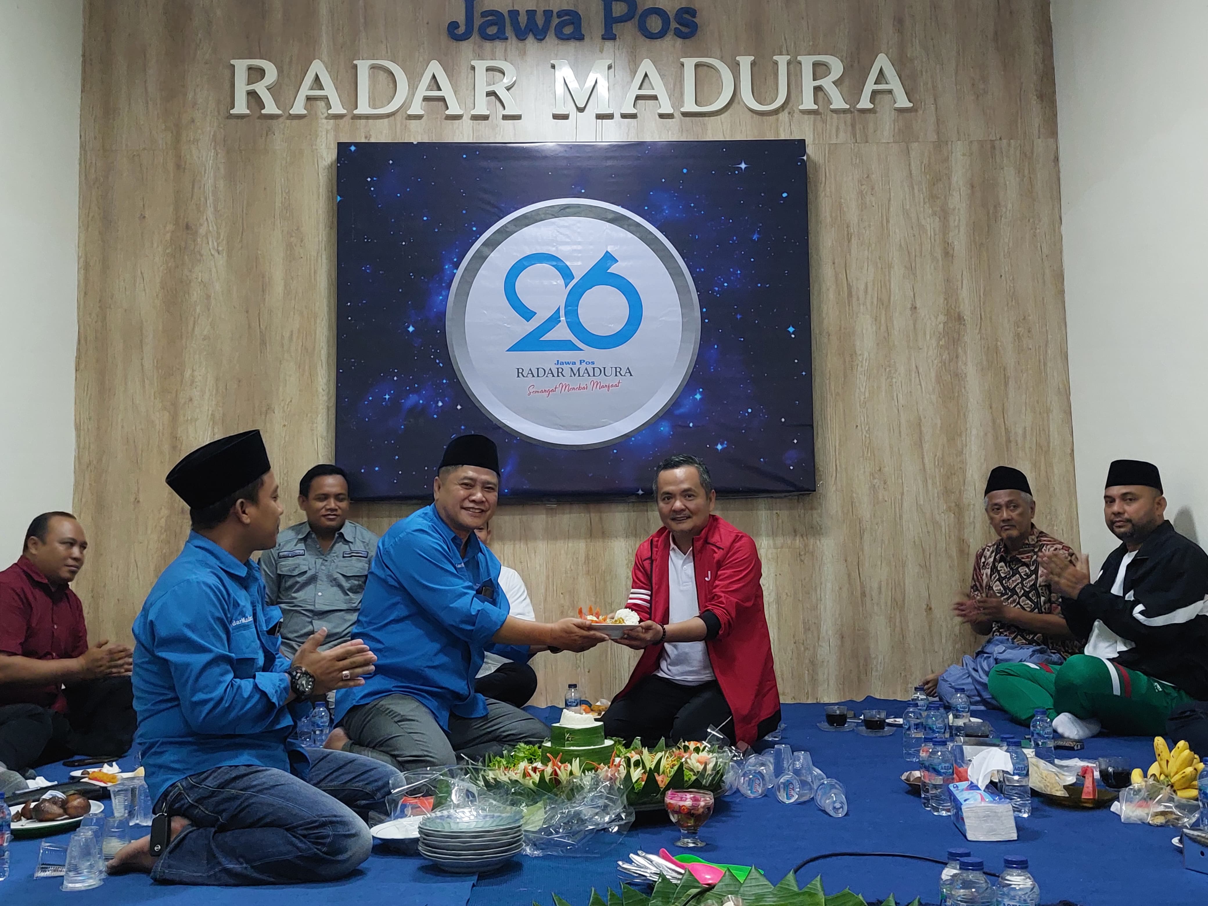 SIMBOLIS: Direktur JPRM Abdul Aziz menyerahkan potongan tumpeng pertama kepada Wakil Bupati Bangkalan Fauzan Jakfar pada tasyakuran HUT ke-26 JPRM di Bangkalan, Minggu (27/7).