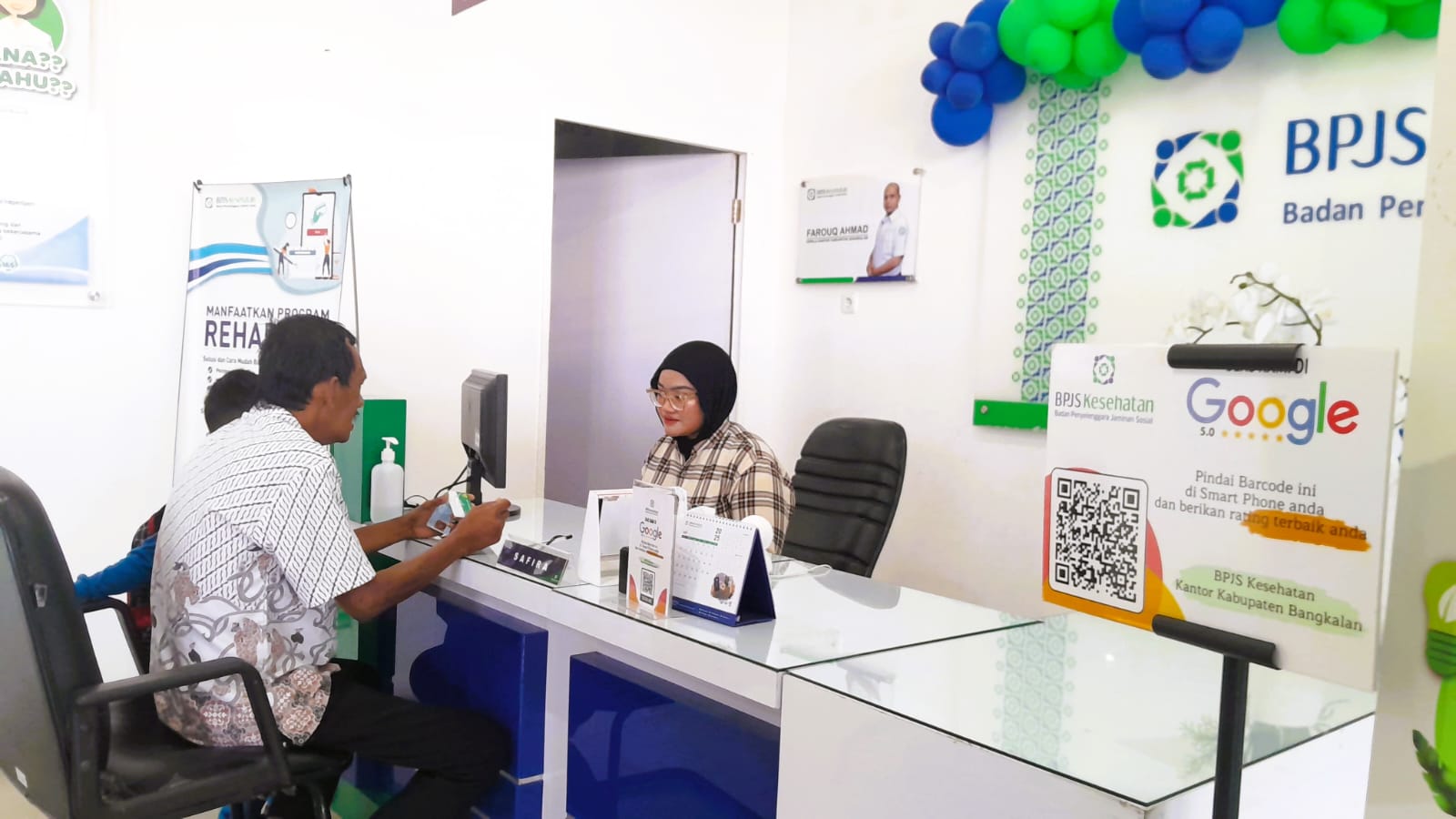 PELAYANAN: Petugas BPJS Kesehatan melayani warga yang datang untuk berkonsultasi di kantor Jalan Halim Perdanakusuma Nomor 15 Bangkalan, Jumat (25/7).