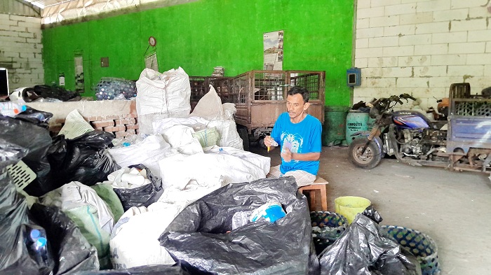 KELOLA SAMPAH: Petugas TP3R Mlajah Berjaya Junaidi sedang memilah sampah, Selasa (29/7). (M. KHOLIL RAMLI/JPRM)