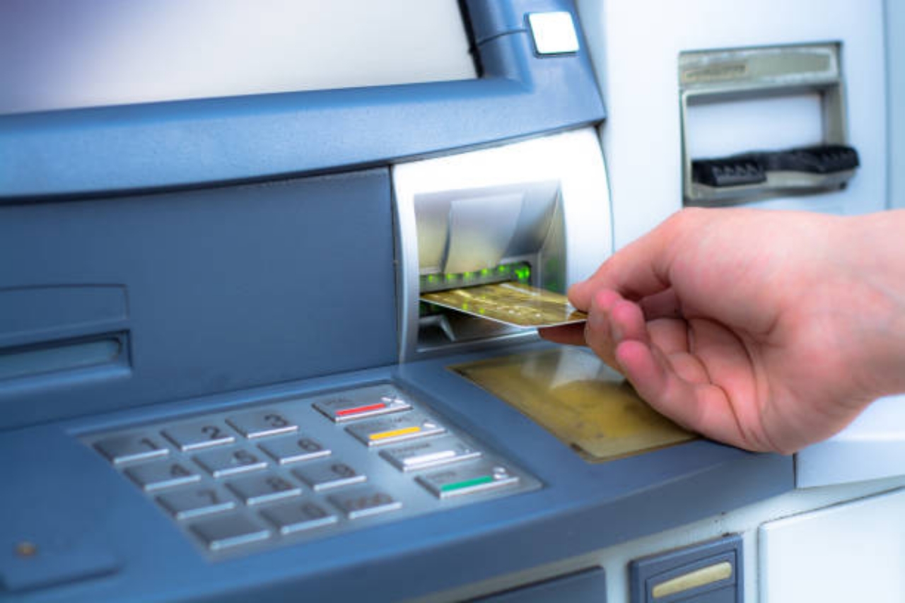 Ilustrasi seseorang yang sedang mengambil uang di ATM.