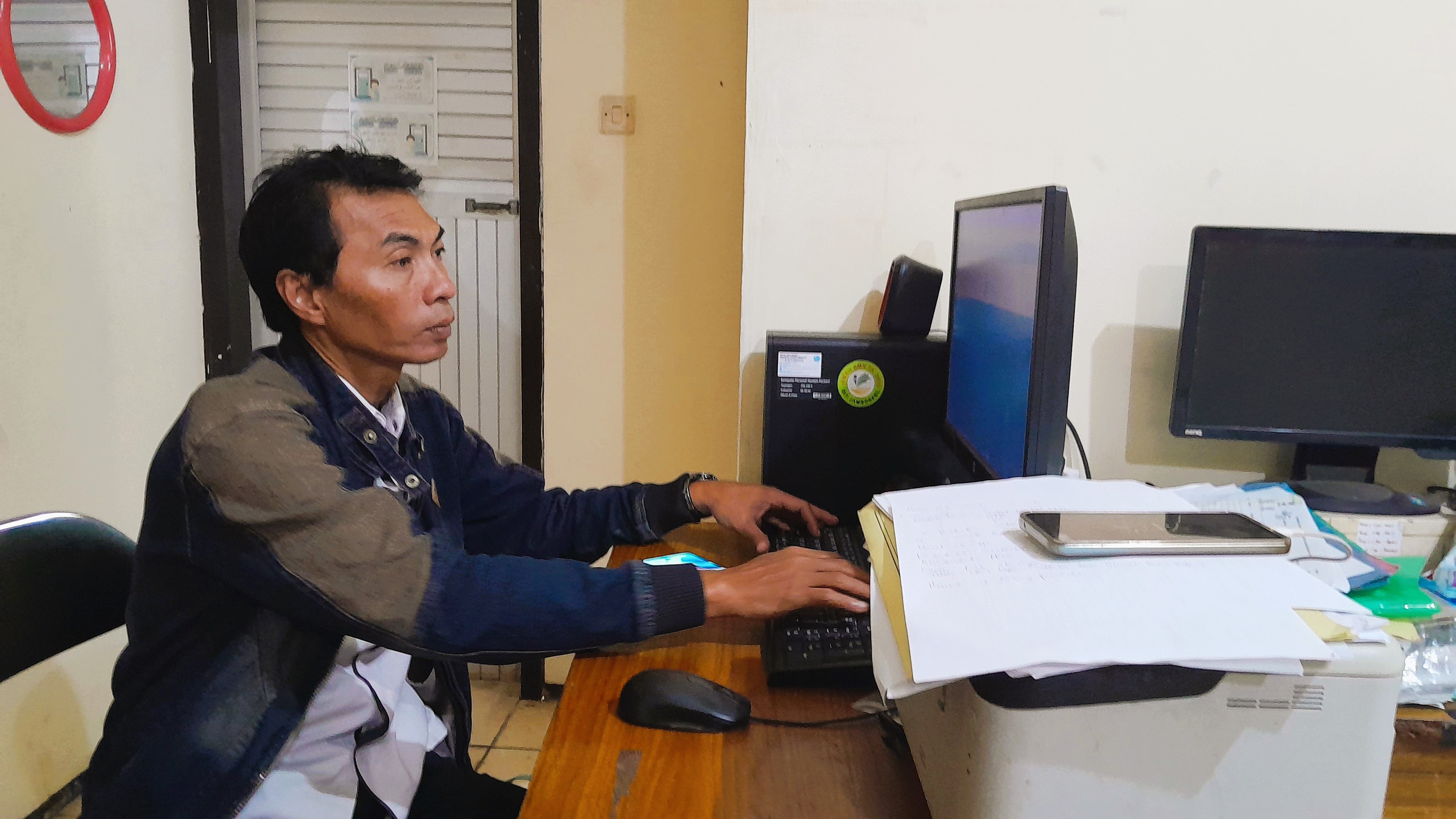 SERIUS: Korkab PKH Bangkalan Heru Wahjudi mengecek data pendamping PKH yang bertugas di Kota Salak Rabu (30/7).