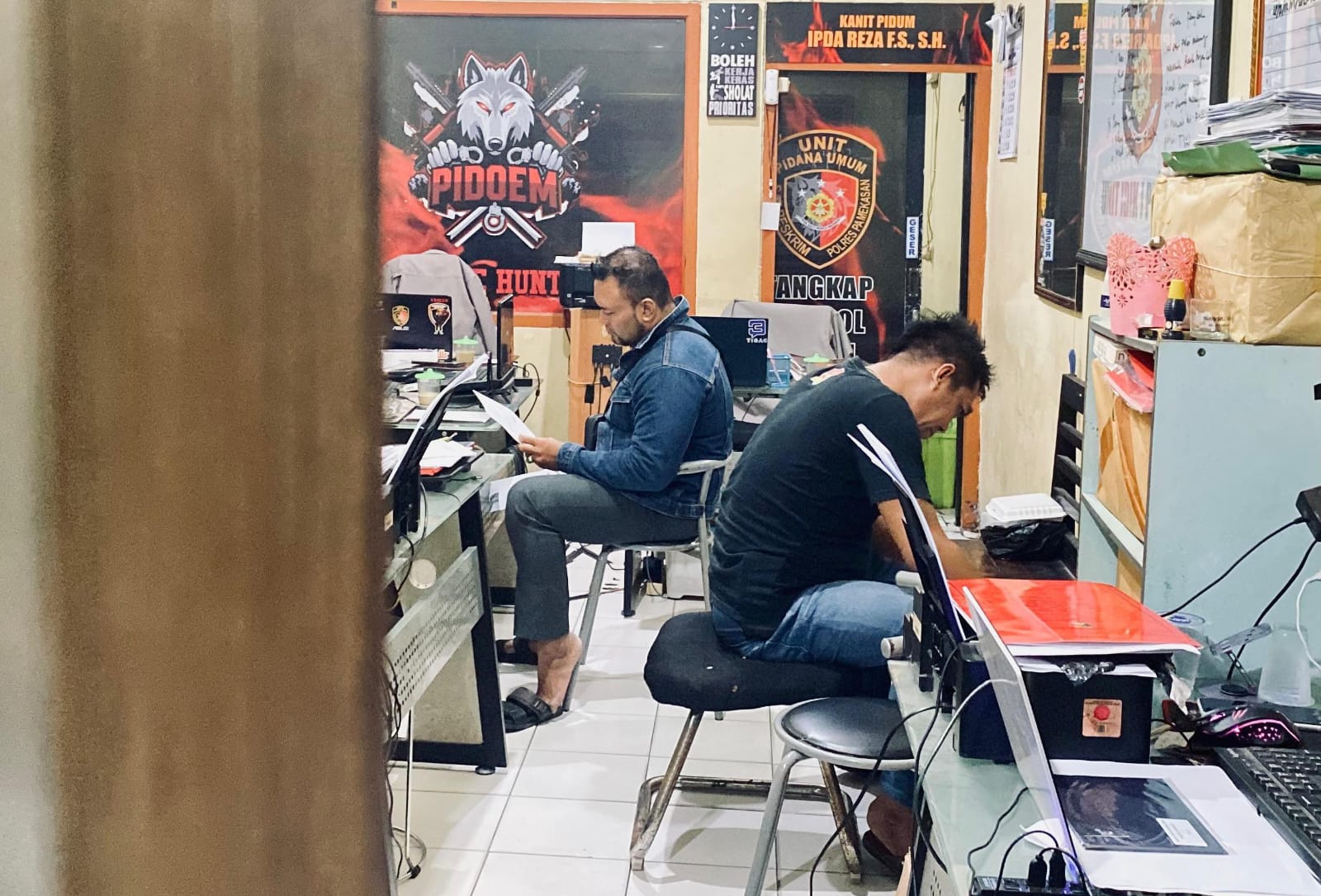 MENYESAL: Zainal Arifin (kemeja jins) duduk di ruang penyidik Satreskrim Polres Pamekasan, Rabu (2/7).