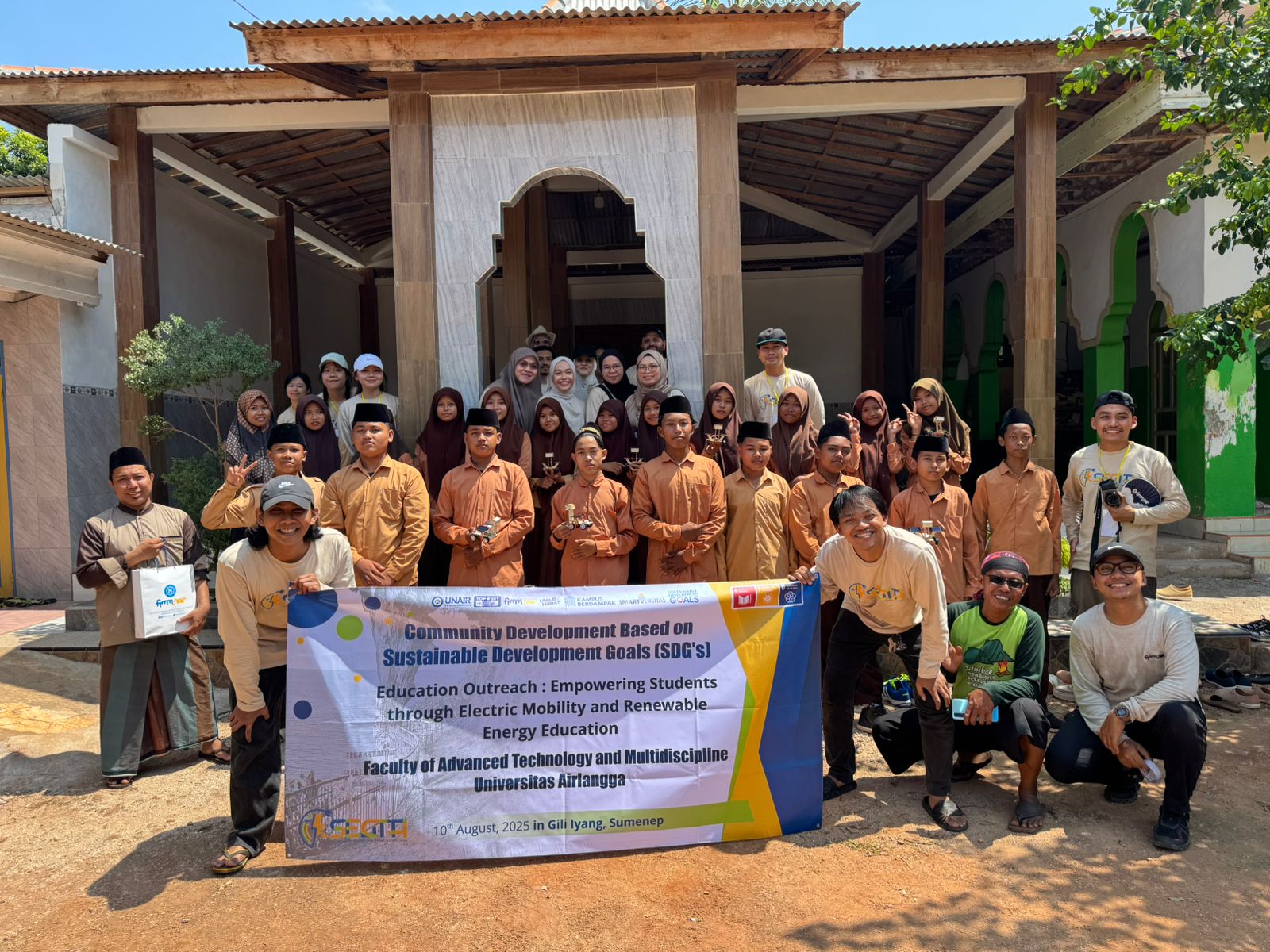 SUKSES: Sejumlah peserta Segta 2025 FTMM UNAIR Surabaya foto bersama warga dan peserta didik usai sosialisasi terkait implementasi solar panel di Desa Banraas, Kecamatan Dungkek pulau giliiyang