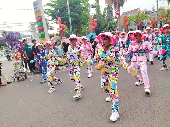 BIKIN HEBOH: Peserta gerak jalan dalam rangka HUT Ke-80 RI mengenakan outfit nyentrik Minggu (10/8). (M. KHOLIL RAMLI/JPRM)