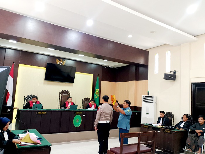DISUMPAH: Anggota Satlantas Polres Sampang Aipda Farid Arif menjadi saksi verbal lisan di Pengadilan Negeri Sampang Selasa (12/8). (UBAIDILLAHIR RAIE/JPRM)