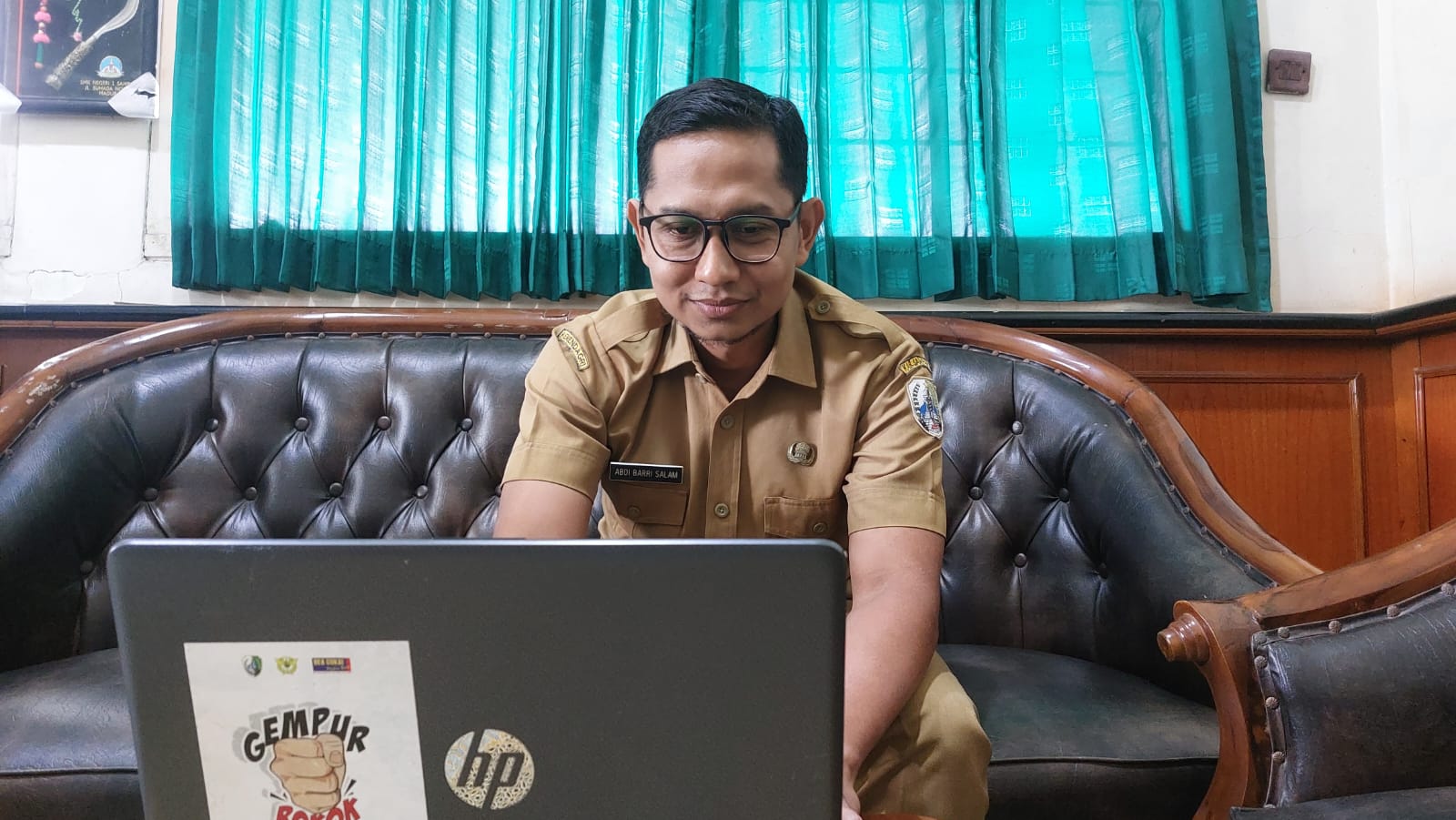 SANTAI: Analis Kebijakan Muda Bagian Perokonomian dan SDA Setkab Sampang Abdi Barri Salam memberikan keterangan di ruang kerjanya.