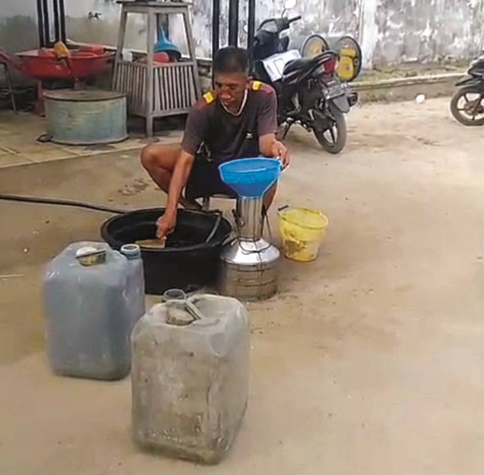 BUTUH PERHATIAN: Seorang nelayan menuang solar di Kecamatan Masalembu, Minggu (10/8). (RENDY UNTUK JPRM)