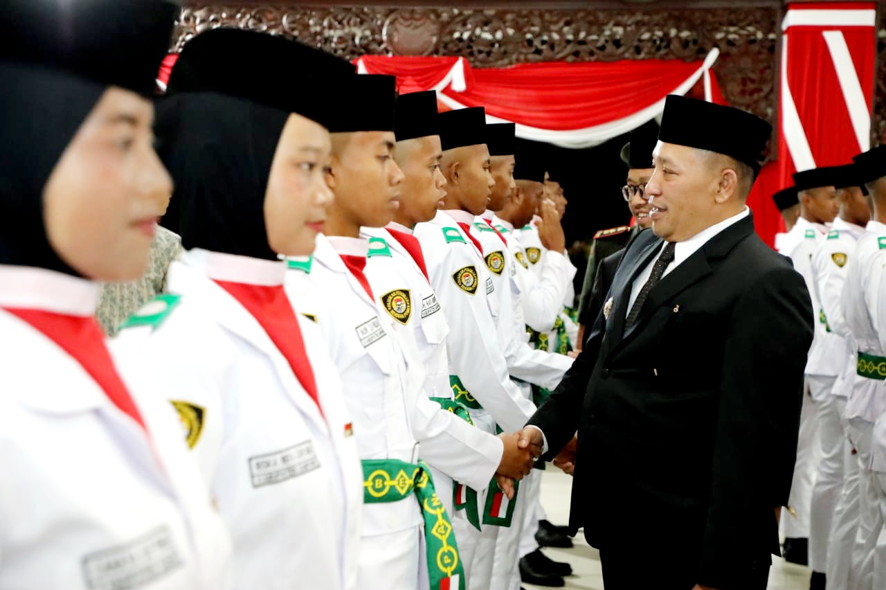BERKARISMA: Bupati Slamet Junaidi menyalami anggota Paskibraka dalam acara pengukuhan di Pendopo Trunojoyo Sampang Jumat (15/8) malam. (PROKOPIM UNTUK JPRM)