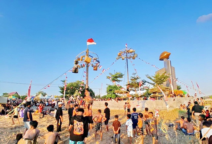 SEMARAK: Warga antusias menyaksikan lomba panjat pinang dalam rangka HUT Ke-80 RI di Desa Kool, Kecamatan Klampis, Bangkalan, Sabtu (16/8). (M. KHOLIL RAMLI/JPRM)